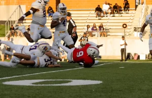 Galveston Ball Dominates Manvel High School in Season Opener at Freedom Field Player jumps over pile, Manvel, Galveston Ball, Football, Varsity Football