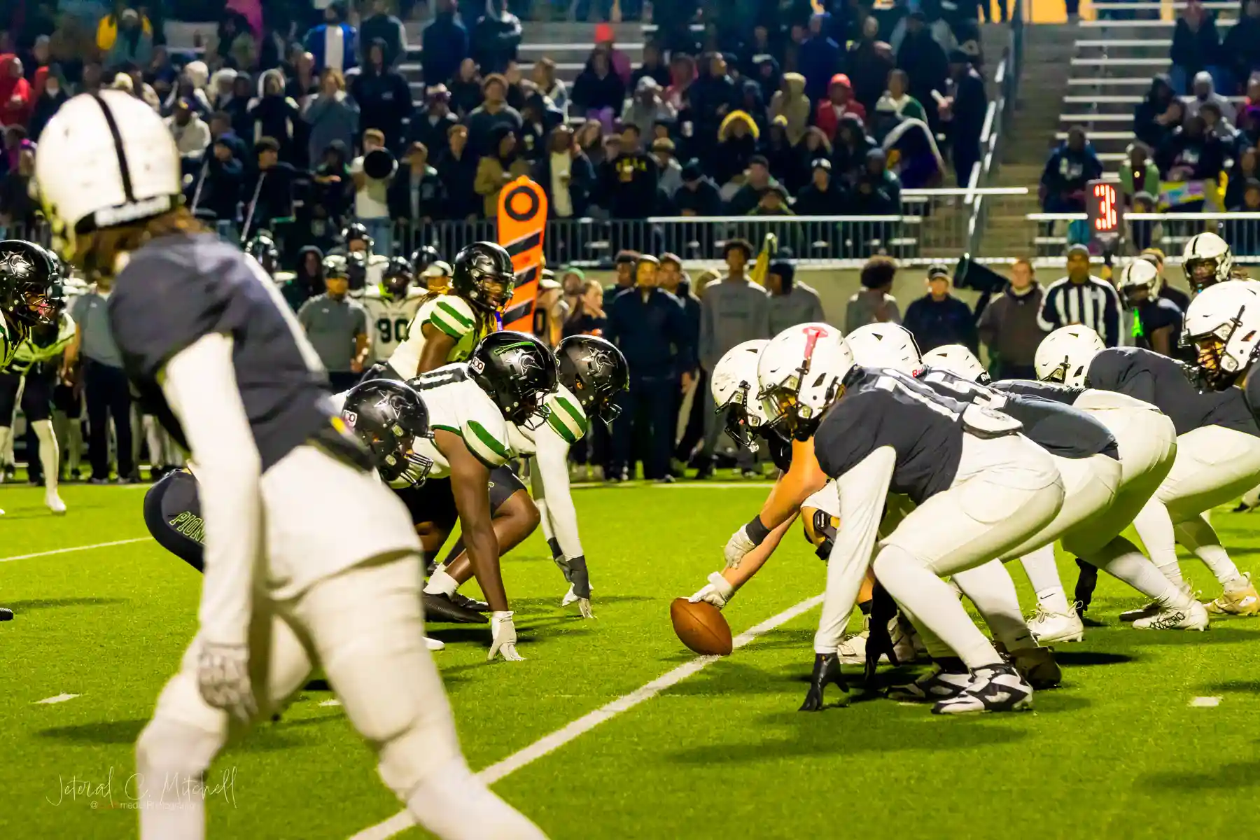 Randle and Iowa Colony linemen set at the line of scrimmage before the snap from a field-level low angle during the 2025 UIL Regional Championship – Photo by JCurtisMedia | GamedaySportsJournal