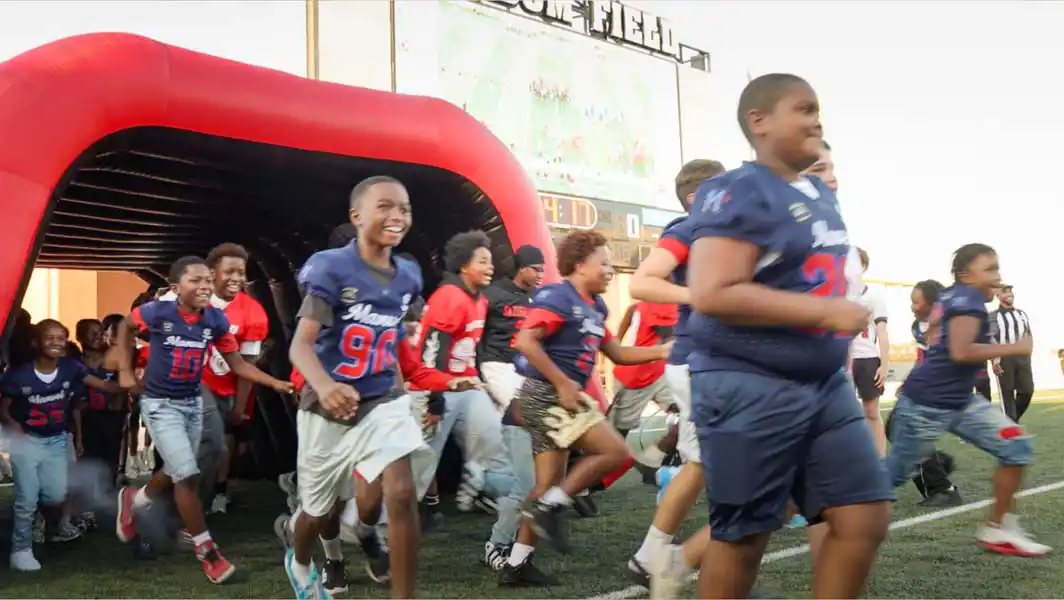 Young football players race out of the tunnel at Alvin ISD Freedom Field